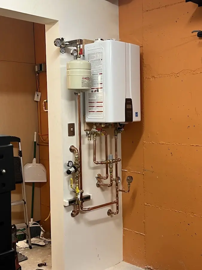 Plumbing technician inspecting water heater connections in Bloomingdale